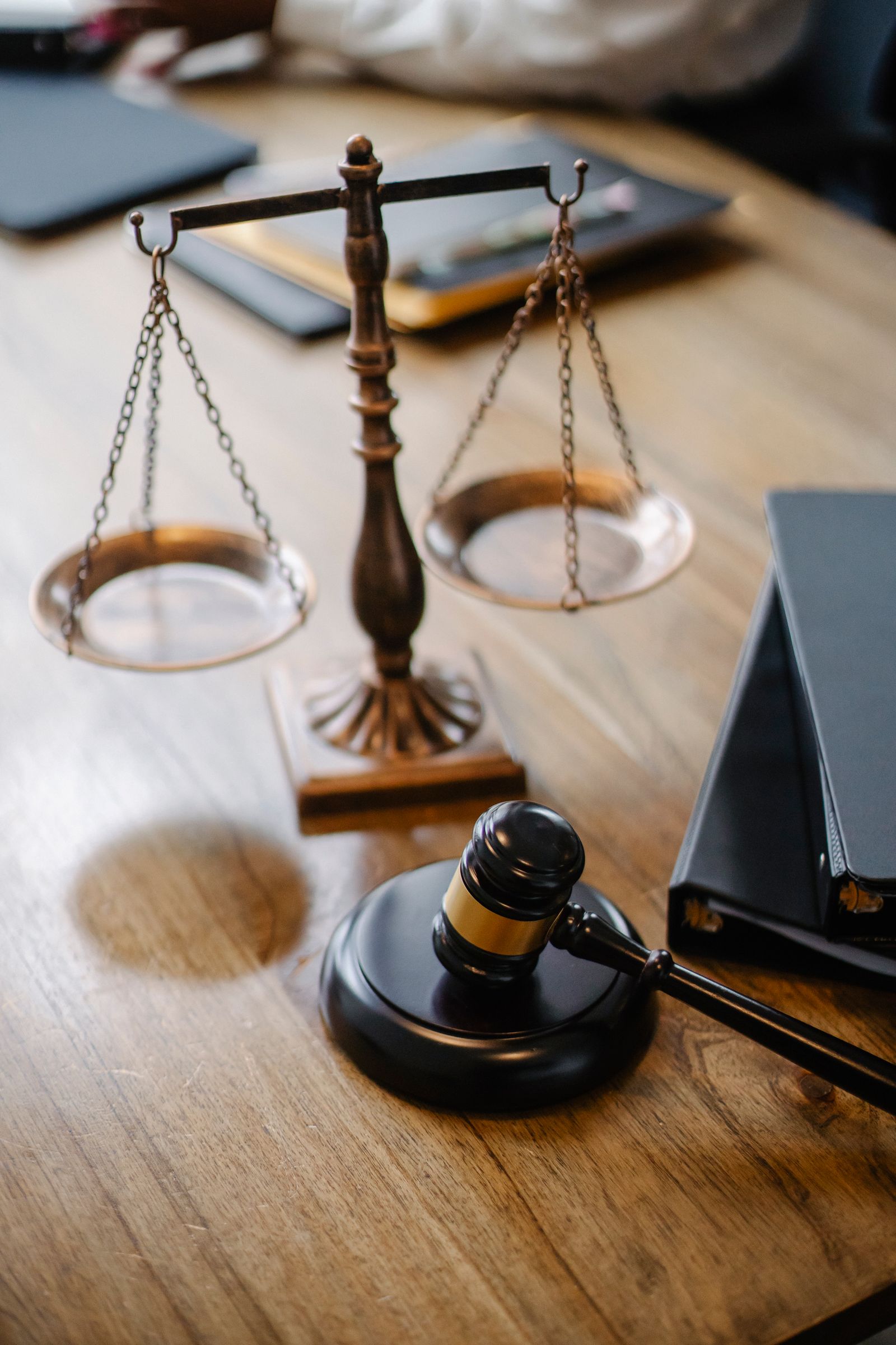 Balanza de la justicia y mazo sobre un escritorio de madera, ambiente jurídico elegante